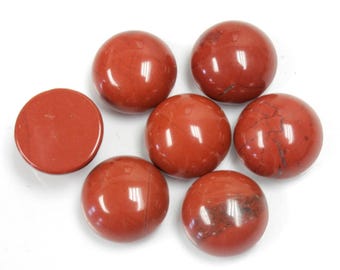 May include: A collection of seven polished, round, red jasper stones. Six are spherical, and one is a flat disc. The stones have a smooth, reflective surface, with natural variations in color and veining.