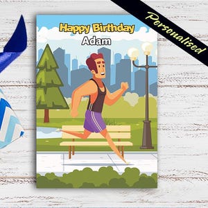 May include: A personalized birthday card with the text "Happy Birthday Adam." The card features a cartoon illustration of a man running in a park setting, with a cityscape in the background. A blue and white gift box with a blue ribbon is in the corner.