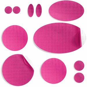 May include: A set of nine pink fabric stickers in various shapes and sizes, including circles, ovals, and rectangles. The stickers have a textured surface and a white backing.