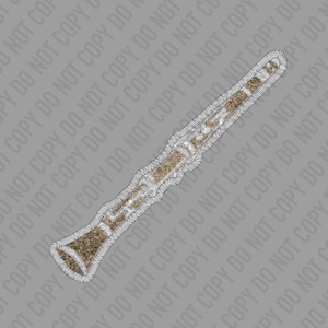 May include: A gold and silver glitter clarinet with a decorative border. The clarinet is a woodwind instrument used in orchestras and bands.