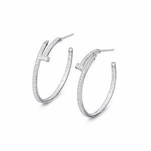 May include: A pair of silver hoop earrings. Each earring features a curved design with a small, rectangular accent encrusted with small, sparkling stones. The hoops are set against a white background.