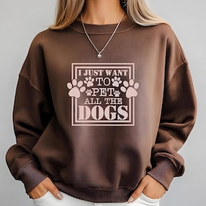 May include: Brown sweatshirt with the text "I just want to pet all the dogs" in a pink box with paw prints.