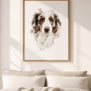 May include: A framed wall art print featuring a watercolour-style portrait of an Australian Shepherd dog. The dog has a white, brown, and merle coat with expressive brown eyes, centred on a plain white background within a light wood frame.