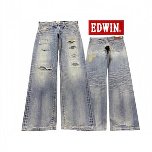 May include: Light blue denim jeans with a distressed finish, featuring multiple patches and frayed rips on the front legs. The back view shows faded whiskering patterns and a brown leather brand patch. The red EDWIN logo is visible above.