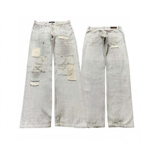 May include: Light-wash denim jeans featuring a wide-leg silhouette, distressed detailing, and multiple frayed patches on the front. The back view displays two pockets, a dark leather-look waistband patch, and a small frayed area on the lower leg.