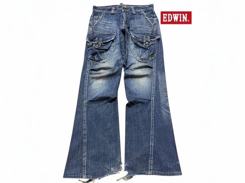 May include: Blue denim jeans with large cargo pockets on the thighs. The jeans have a faded wash and a flared leg design. The brand name "EDWIN" is displayed in a red rectangle.