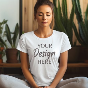 May include: A white t-shirt with the text "YOUR Design HERE" printed on the front. The shirt is being worn by a person sitting in a yoga pose.