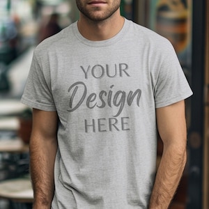 Może przedstawiać: Szary t-shirt z nadrukiem "YOUR Design HERE" na przodzie.