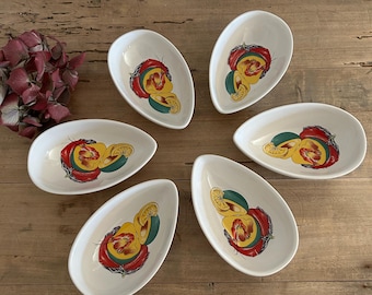 May include: Set of six white ceramic serving dishes with a unique design featuring a red pepper, green pepper, and lemon slices. The dishes are oval shaped and have a glossy finish.
