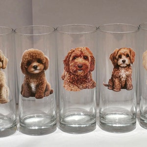 May include: Set of ten clear glass tumblers featuring various dog breeds printed on them. The dogs include a poodle, a golden retriever, and a labrador.