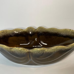 May include: A brown and green ceramic serving bowl with a wavy edge and a glossy finish.