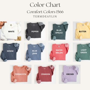 May include: Color chart showcasing Comfort Colors 1566 sweatshirts in various hues. The image displays sweatshirts in white, pepper, blue spruce, butter, denim, blue jean, watermelon, light green, terracotta, crimson, and orchid.