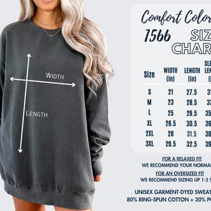 May include: A dark gray unisex garment-dyed sweatshirt with a size chart. The chart lists measurements in inches for width, length, and sleeve length. The sweatshirt is made of 80% ring-spun cotton and 20% polyester.