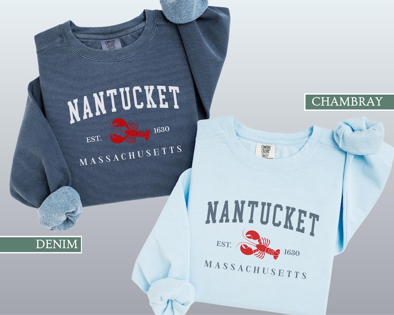 May include: Two crewneck sweatshirts, one denim blue and one chambray blue, with the word "NANTUCKET" in white block letters. Below the word is a red lobster graphic and the text "EST. 1630 MASSACHUSETTS".