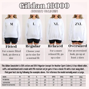 K&ouml;nnte beinhalten: Ein wei&szlig;es Gildan 18000 Crewneck-Sweatshirt wird an vier Models pr&auml;sentiert, die jeweils eine andere Gr&ouml;&szlig;e tragen: M, L, XL und 2XL. Das Bild enth&auml;lt eine Gr&ouml;&szlig;entabelle mit Ma&szlig;en in cm und Beschreibungen f&uuml;r verschiedene Passformen.