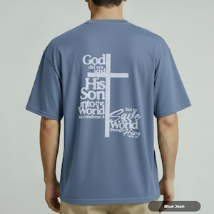 Puede incluir: Camiseta azul vaquero con texto blanco y cruz en la espalda. El texto dice: «Porque no envió Dios a su Hijo al mundo para condenar al mundo, sino para que el mundo sea salvo por él. Juan 3:17».