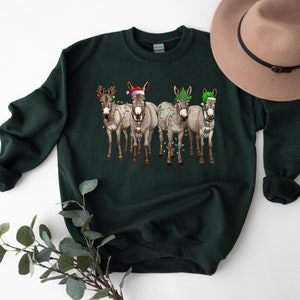 May include: A dark green sweatshirt with a Christmas-themed design featuring four donkeys wearing Santa hats and Christmas lights.