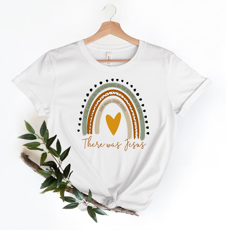 May include: White t-shirt with a rainbow design featuring the text "In the morning, in the sunshine, in the evening, in the healing of the day, every minute, every moment, there was Jesus".