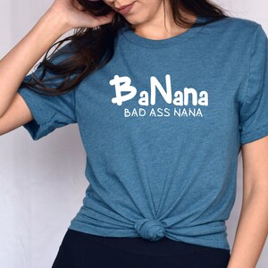 May include: A teal blue t-shirt with the text "BaNana BAD ASS NANA" in white.