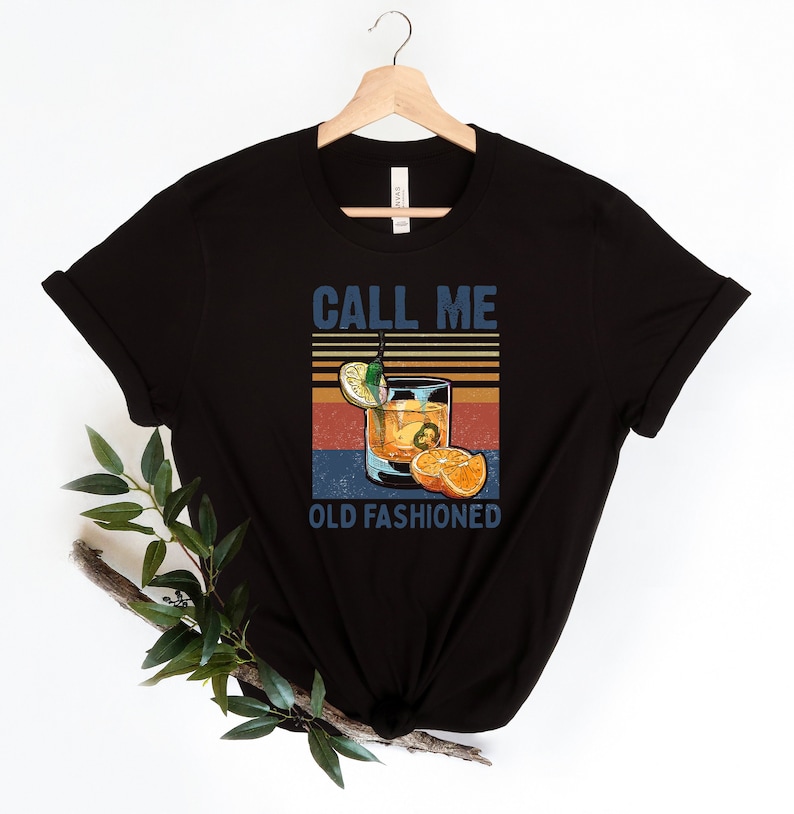 May include: Black t-shirt with a vintage-style graphic of an old fashioned cocktail and the text "Call Me Old Fashioned".