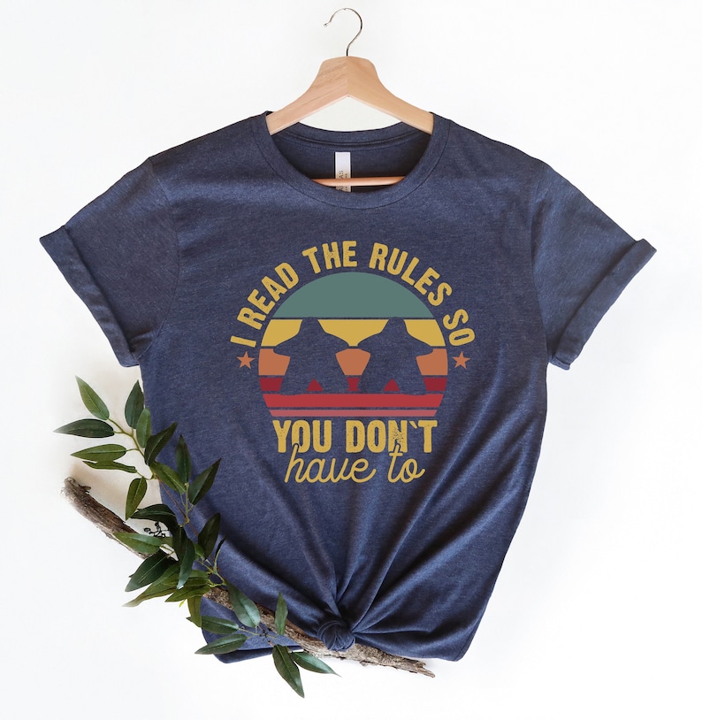 May include: A navy blue t-shirt with a vintage-style graphic that says "I read the rules so you don't have to".