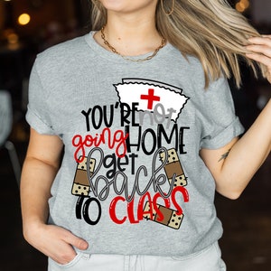May include: Gray t-shirt with a red cross and the text "YOU'RE not going HOME get back to CLASS" with brown bandage graphics.