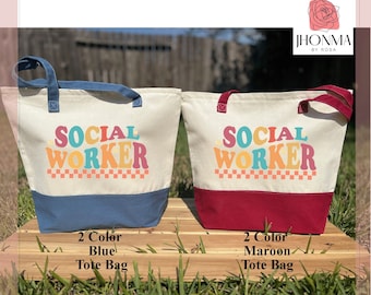 May include: Two tote bags with the text "SOCIAL WORKER" in a retro font. The bag on the left has a blue bottom and the bag on the right has a maroon bottom.