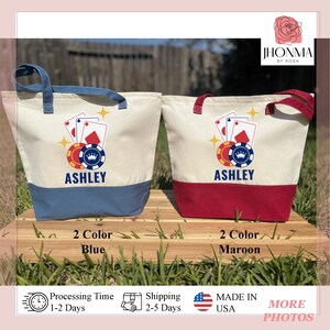 May include: Two canvas tote bags with a design of playing cards and poker chips. The bags are personalized with the name "Ashley". One bag has a blue bottom and the other has a maroon bottom.