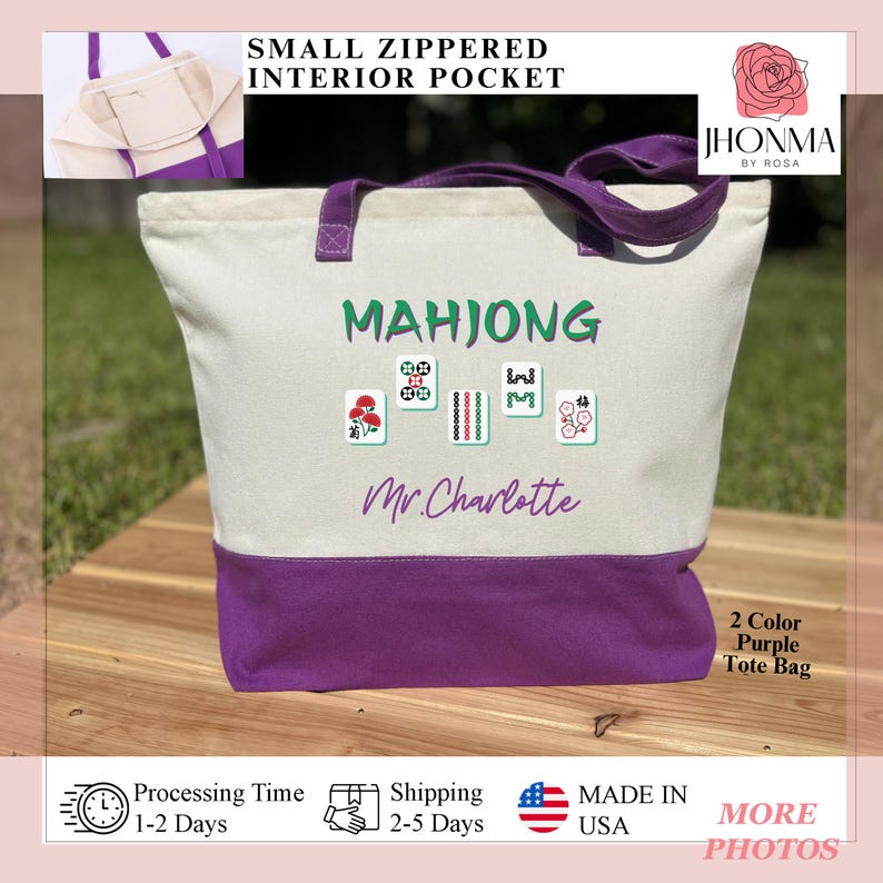May include: A white canvas tote bag with a purple bottom. The bag has a small zippered pocket on the inside. The bag is personalized with the text "Mahjong" and "Mr. Charlotte" in black. The bag is decorated with four mahjong tiles with red, green, and white designs. The bag is a two-color purple tote bag.