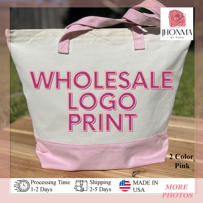 Pu&ograve; includere: Una borsa tote in tela bianca con manici rosa e fondo rosa. La borsa presenta il testo "WHOLESALE LOGO PRINT" in lettere rosa e bordeaux.
