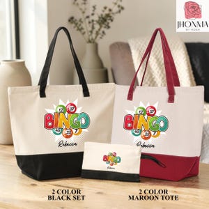 May include: Two canvas tote bags and one small pouch featuring a colorful bingo graphic with the text BINGO and the name Rebecca. One tote has black handles and a black base, while the other has maroon handles and a maroon base. The pouch is black.