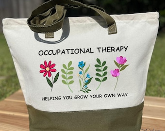 May include: A canvas tote bag with a zipper, featuring the text "OCCUPATIONAL THERAPY" and the phrase "HELPING YOU GROW YOUR OWN WAY." The bag has a white upper section and a green lower section, with green handles. Floral illustrations are also present.