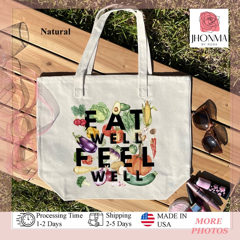Może przedstawiać: Biała torba z pł&oacute;tna z napisem "Eat Well Feel Well" czarnymi literami, otoczona kolorowymi ilustracjami r&oacute;żnych owoc&oacute;w i warzyw.