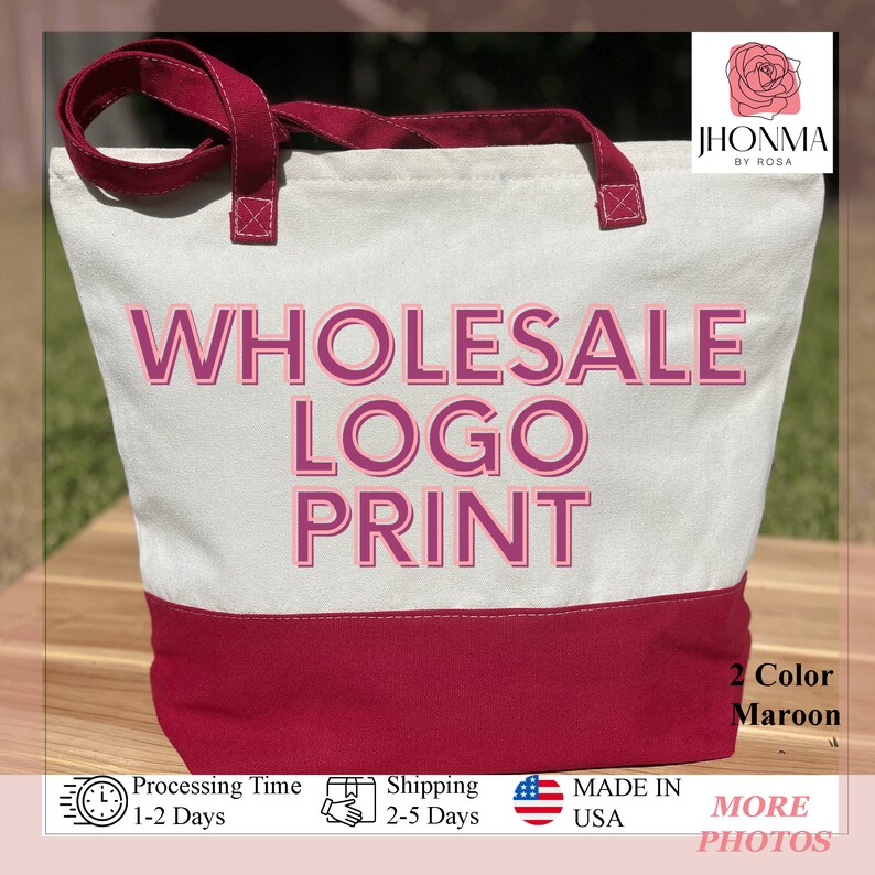 Pu&ograve; includere: Una borsa tote in tela bianca con bordi e manici marroni. La borsa ha il testo "WHOLESALE LOGO PRINT" in lettere rosa. La borsa &egrave; appoggiata su una superficie di legno.