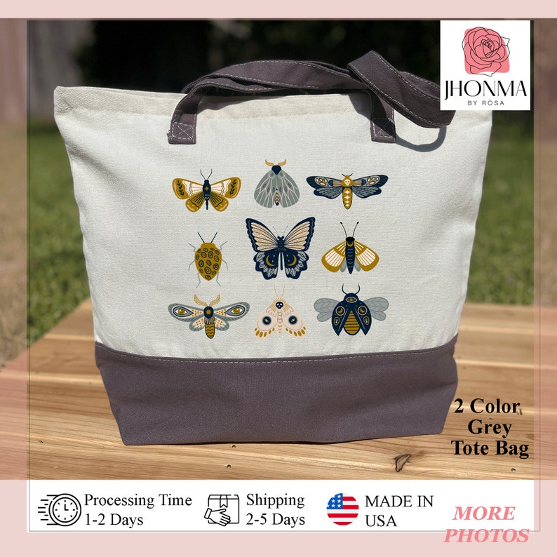 May include: A grey canvas tote bag with a design of various butterflies and moths in shades of blue, yellow, and white. The bag has a grey bottom and two grey handles.