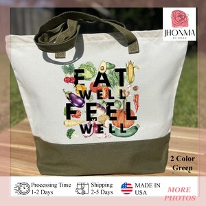 Może przedstawiać: Zielona i biała torba z pł&oacute;tna z napisem "EAT WELL FEEL WELL" czarnymi literami. Torba jest ozdobiona r&oacute;żnymi kolorowymi warzywami i owocami.