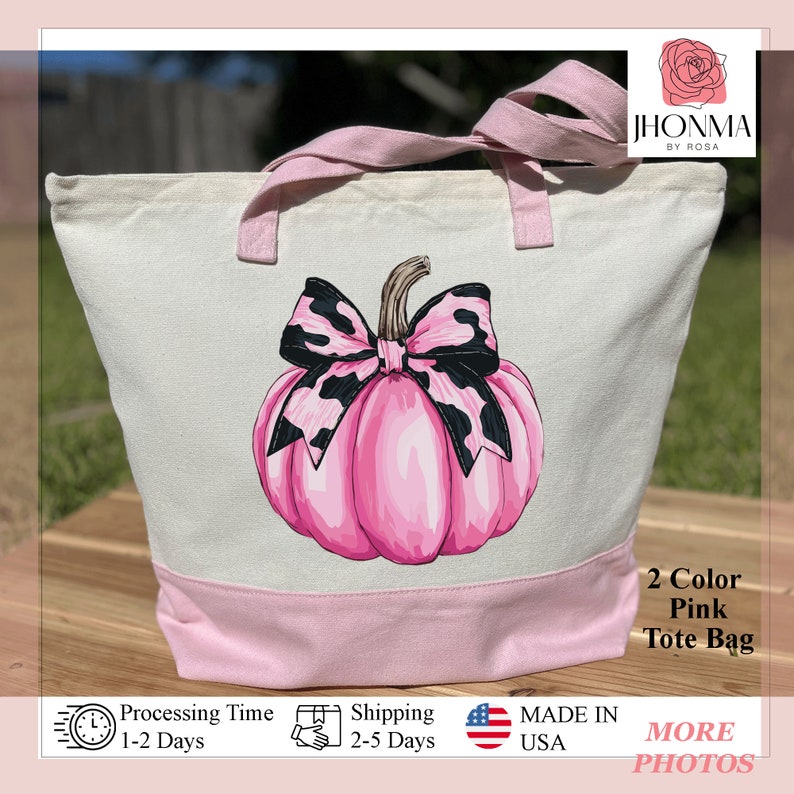 May include: A pink tote bag with a pink pumpkin and a black and white bow. The bag has a pink bottom and white top. The text "2 Color Pink Tote Bag" is on the bag.