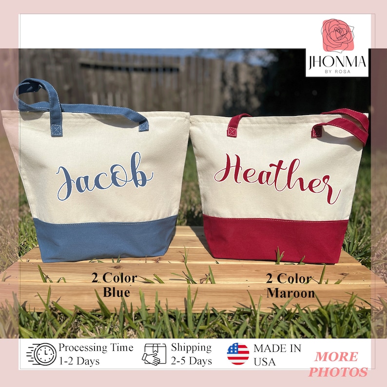 May include: Two personalized canvas tote bags with contrasting colored bottoms. The bag on the left is white with blue lettering and a blue bottom. The bag on the right is white with maroon lettering and a maroon bottom. The bags are labeled "Jacob" and "Heather".