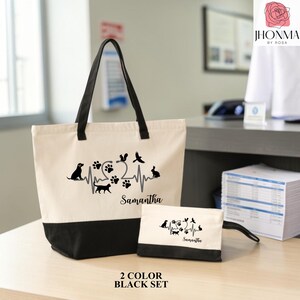 May include: A two-piece set consisting of a large tote bag and a smaller pouch, both made of cream-colored canvas with black bases and black handles. The bags feature a black graphic of a heartbeat line with animal silhouettes and the name Samantha.