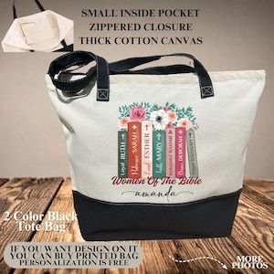 May include: A two-tone tote bag with a black base and cream-colored upper section. The bag features a floral design above a stack of books with names like "Esther" and "Deborah." The text "Women of the Bible" and "amanda" are also printed on the bag.