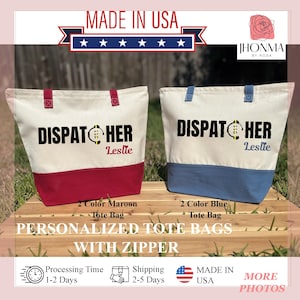 May include: Two personalized tote bags with zipper closures. The bags are made of canvas with a white top and a colored bottom. The left bag has a maroon bottom and the right bag has a blue bottom. Both bags have the text "DISPATCHER" with a small graphic of a phone and the name "Leslie" printed on them. The bags are displayed on a wooden surface.