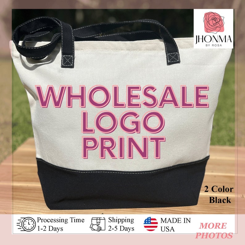 Pu&ograve; includere: Una borsa tote in tela bianca con manici neri e fondo nero. La borsa ha il testo "WHOLESALE LOGO PRINT" in lettere rosa. La borsa &egrave; appoggiata su una superficie di legno.