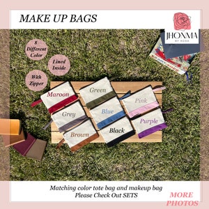 May include: Eight different color makeup bags with zipper closures. The bags are lined and have a white canvas exterior with a colored bottom. The colors are maroon, grey, green, blue, pink, purple, black, and brown.