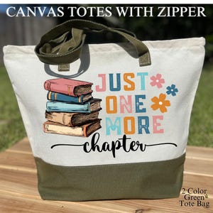 May include: A canvas tote bag with a zipper, featuring a design with stacked books and the text "JUST ONE MORE chapter." The bag has a white upper section, a green bottom, and green handles. The words "2-Color Green Tote Bag" are also visible.