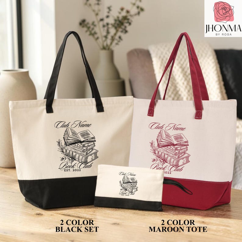 two tote bags, one black and one maroon, placed on a wooden surface. The black tote bag has a white tote bag with a black book illustration on it, and the maroon tote bag has a white tote bag with a maroon book illustration on it. The bags are arranged in a row, with the black tote bag positioned slightly ahead of the maroon tote bag.