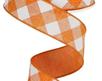 Peut inclure: Un rouleau de ruban blanc avec un motif à carreaux orange et blanc répété. Le ruban est déroulé, révélant un dessous orange uni. Le ruban est probablement utilisé pour l'artisanat, l'emballage de cadeaux ou les décorations.