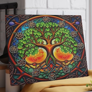 Puede incluir: Arte en lienzo cuadrado con un vibrante diseño del Árbol de la Vida. La obra de arte muestra un árbol con hojas verdes, un tronco marrón e intrincados nudos celtas. El fondo tiene un efecto de vidriera con cálidos tonos naranja y amarillo.