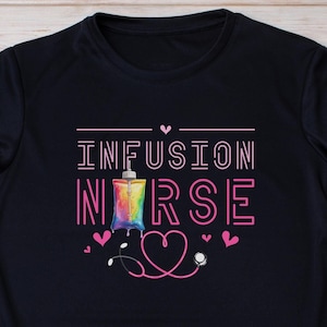 May include: Black t-shirt with the text "INFUSION NURSE" in pink and white lettering. A rainbow-colored IV bag with a pink heart is in the center of the text. A pink stethoscope with a heart is below the text.