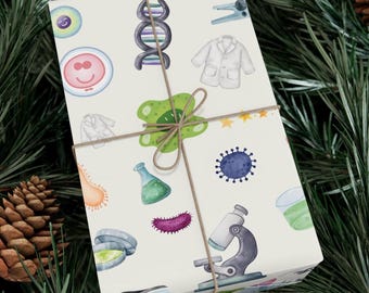 May include: White wrapping paper with a repeating pattern of science-themed illustrations. The illustrations include a microscope, a DNA strand, a lab coat, a beaker, a petri dish, a virus, a bacteria, and a cell. The paper is tied with a brown ribbon.