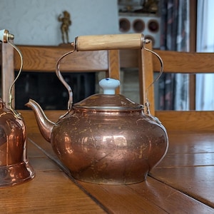 Petite bouilloire vintage en cuivre avec manche en bois et poignée en céramique sur le couvercle pour les cuisines rustiques